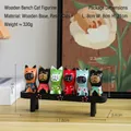 Set of six colorful resin cat figurines on a black wooden bench for home desktop decoration - 6-Piece Cat Set with Wooden Bench