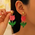 Nahaufnahme von rosa Tulpen-Acryl-Ohrringen mit grünen Blättern am Ohr - Rosa Tulpen-Ohrhänger (H-172)