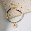Natural pearl bracelet with blue crystals and a gold avocado pendant detail - Natural Freshwater Pearl Avocado Pendant Bracelet