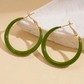 Macro view of green resin crescent hoop earrings with gold metal posts on marble - Hoop Earrings-Green-Gold Buckle