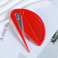 Close-up of red leaf-shaped safety cutter with embedded blade for opening boxes - Red