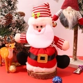 Detail of plush Santa Claus gift bag with striped hat, bell, and belt on a festive scene - Santa Claus