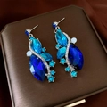 Dettaglio degli orecchini a goccia con cristalli blu e strass su portagioie - Perno in argento - Argento - Blu