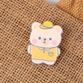 Cute Korean acrylic bear brooch wearing yellow baseball cap on brown woven texture background - Mr. Bear