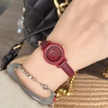 Elegant gold quartz watch with red leather strap shown on a woman wrist with accessories - Gold/Red (Round Mikio Style)