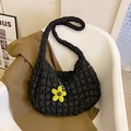 Black quilted bubble tote bag with yellow flower charm on a white minimalist chair - Black With Pendant