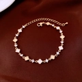 Dettaglio di un bracciale a quadrifoglio dorato con madreperla bianca e zirconi - Oro Bianco