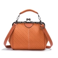 Close-up of orange-brown woven texture bag with floral metal kiss-lock and top handle - Orange