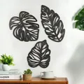 Detail von drei schwarzen lasergeschnittenen Monstera-Wandbildern aus Holz in modernem Raum - KY2063/3er-Set/Schwarz