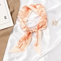 Elegant beige silk scarf with orange feather print tied in a bow on satin fabric - Letter I - Orange Feather Plant