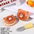 Detalle macro de mini dijes de galleta de oso en resina con medidas de 1,8 cm de largo - Pan de Sándwich de Oso Pardo