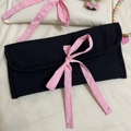Vue à plat de trousses en tissu noir et blanc avec détails de nœuds en ruban de satin rose - Noir