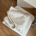 Bolso tote de algodón con flores azules sobre silla, mostrando detalles de tela y textura - Estampado Floral Pequeño Azul Claro