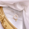 Detailed macro view of a freshwater pearl ring with a golden letter D hanging charm - Letter D