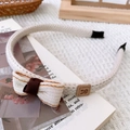 Detail of knitted bow headband in cream white with brown leather rabbit tag accents - White