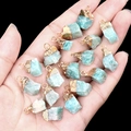 Natural teal agate stone pendant with gold plated edge held in hand for jewelry making - Amazonite
