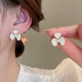 Close-up of white clover stud earring with gold border and pearl on a model ear - Gold-Blue Clover (53# Silver Earring Post)