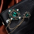 Vintage emerald brooch with gold tassel chains and pearls on a dark textured background - TL003-Green-Gemstone