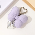 Détail d'un porte-clés noeud en tissu violet rembourré avec pendentif coeur en métal - Violet