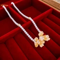 Macro detail of a freshwater pearl necklace with yellow crystal pendant in a red box - Orange Crystal Flower Style