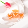 Gros plan d'une pince à cheveux orange translucide avec des motifs de cœurs roses - 10cm / Couleur Gelée