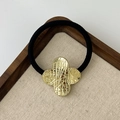 Elastic hair tie with a gold textured clover-shaped metal ornament on black rubber band - Textured Clover Gold