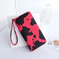 Pink and black cow print long wallet with wrist strap and secure zipper closure - Red