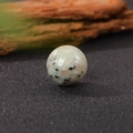 Polished 20mm round green gemstone sphere with black and brown spots on black surface - 20*20mm / Tianshan Blue