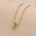 Close-up of golden necklace featuring a crystal-encrusted letter J pendant on a fine chain - Letter J