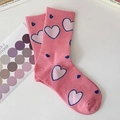 Detail of pink cotton crew socks featuring white and blue heart patterns on a white table - One Size / Heart