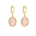 Elegante goldene Evil Eye Ohrringe mit rosa Emaille und Kristallen auf weißem Hintergrund - Rosa