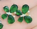 Handheld view of butterfly earrings featuring green water-drop stones and gold plating - Gold Plated Green Stone