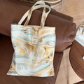 Detailed close-up of marble pattern canvas tote bag resting on a leather sofa - Double Strap Shoulder Bag