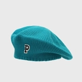 Close-up of teal knit beret showing textured wool pattern and a stylish P letter patch - Teal
