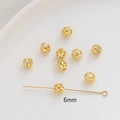 Detailed macro view of 6mm gold hollow spacer beads with intricate floral patterns for DIY - 6mm / 18K Gold