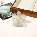 Detailed view of a white pearlescent flower hair claw clip with a glossy resin finish - PVC 7cm Flower - Iridescent Grey