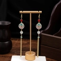 Golden long tassel earrings with red beads and pink stone on a professional display - Ruyi Pattern Long Tassel Style (E1512-3)