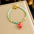 Rainbow beaded bracelet with a red strawberry charm on a golden chain display - Double Layer Strawberry Beaded Style (B1850)