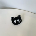 Top view of a glossy black cat acrylic hair claw clip on a clean white surface - Cat