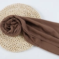 Dark brown chiffon hijab scarf with pearls on a straw mat and white background - 122