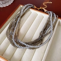Dettaglio di elegante collana a più strati con perle grigie in una scatola per gioielli - Grigio