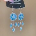 Vista detallada de pendientes de plata S925 con piedras azules y elegantes flecos largos - Estilo Gancho Oro-Azul
