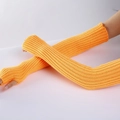 Close-up of yellow knitted arm warmers with a vertical ribbed pattern and fingerless design - Orange