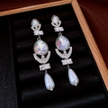 Macro detail of long pearl drop earrings with iridescent crystals on black velvet tray - Silver Iridescent Moon Style