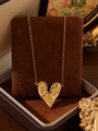 Macro shot of 18k gold heart pendant with textured finish on brown velvet box - Lava Heart (ZHN2401 Gold)