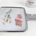 Pink marble pattern acetate hair claw clip for women shown on a reflective mirror - Ice Crystal Pink