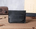 Close-up of black crazy horse leather card holder on a rustic wooden desk with accessories - Black