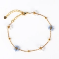 Gold-plated chain bracelet featuring woven blue crystals and white pearl flower charms - Bracelet / Blue and White Floral
