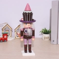 Pink Christmas nutcracker puppet with cake hat and glitter decor on wooden desk - 26cm Brown Cake Man