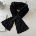 Detail eines schwarzen Kunstpelz-Strickschals mit Kreuzdesign auf weißer Fläche - Schwarz